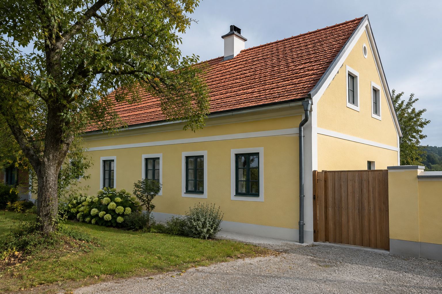 Haus mit sonnengelber Fassade und rotem Ziegeldach