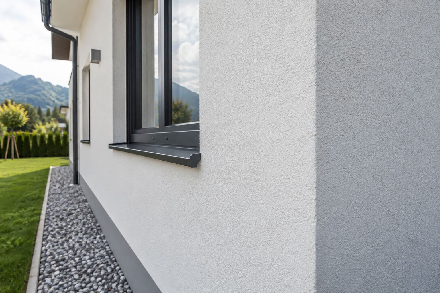 Nahaufnahme einer frisch sanierten Putzfassade am Fenster
